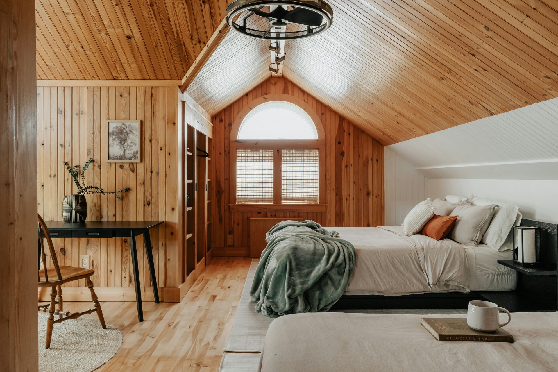 A bedroom with two beds and a desk